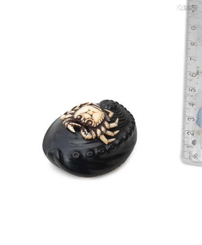 By Seikan, 19th century An ebony and stag-antler netsuke of a crab on an awabi (abalone) shell