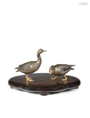 By Kano Seiun (born 1871), Meiji (1868-1912) or Taisho (1912-1926) era, late 19th/early 20th century A pair of large inlaid shibuichi geese on a lacquered-wood stand