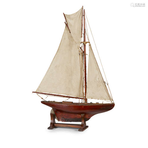 SMALL POND YACHT LATE 19TH CENTURY with canvas sails and metal fittings, on a mahogany stand 70cm