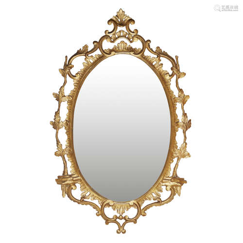 GEORGE III GILTWOOD MIRROR 18TH CENTURY the oval mirror plate in a giltwood frame with C and leaf