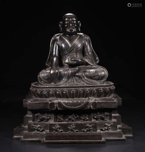 A BRONZE SITTING BUDDHA FIGURE WITH EMBEDDED SILVER