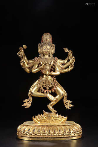 A GILT BRONZE FEMALE BUDDHA FIGURE WITH FOUR FACES AND EIGHT ARMS