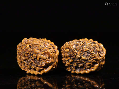 A PAIR OF WALNUTS CARVED FIGURE PATTERN