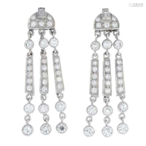 A pair of diamond earrings. Each designed as a