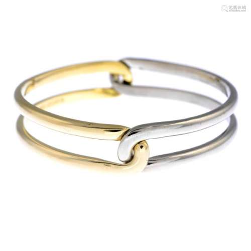 CARTIER - an 18ct gold bangle. Designed as two,