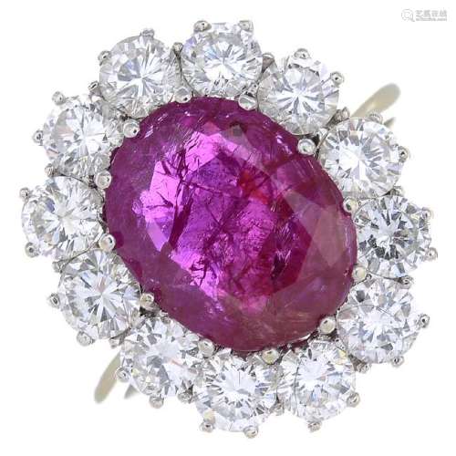 A ruby and diamond cluster ring. The oval-shape ruby,