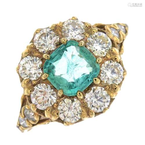An emerald and diamond cluster ring. The cushion-shape