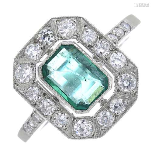 An emerald and diamond cluster ring. The