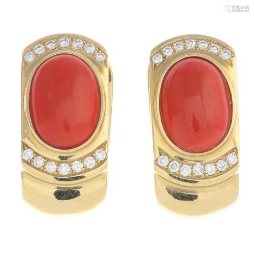 A pair of coral and diamond earrings. Each designed as