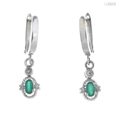 A pair of emerald and diamond earrings. Each designed