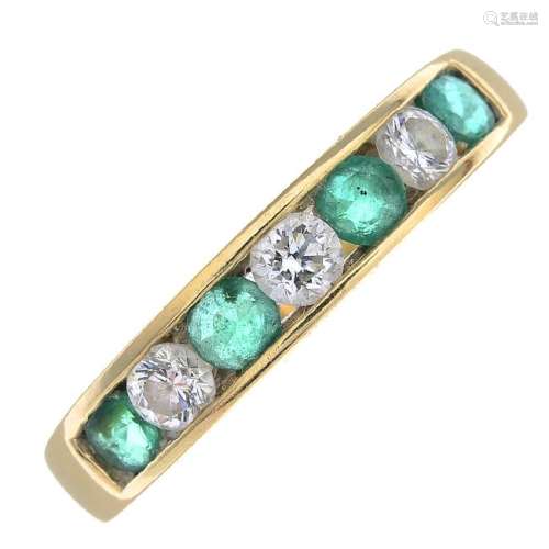 An emerald and diamond half eternity ring. The