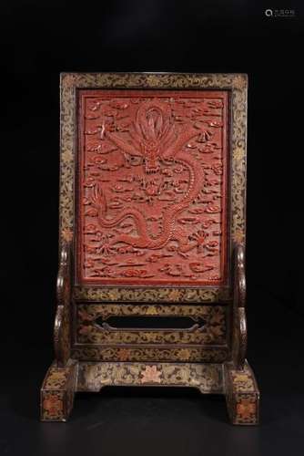 A CARVED CINNABAR LACQUER AND GILT-DECORATE DRAGON