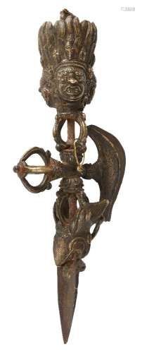 A Tibetan bronze phurba, 19th century, with three-headed deity handle above crossed karttrka, the