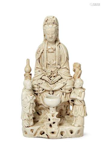 A Chinese Dehua porcelain Guanyin figure group, 17th century, depicting Guanyin seated in front of a