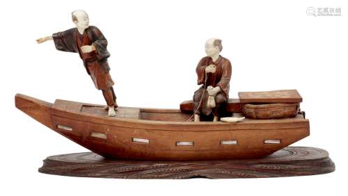A Japanese wood and ivory fishing boat okimono, Meiji period, carved with two fishermen, one