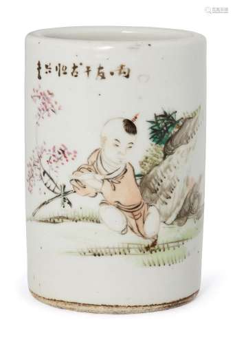 A Chinese porcelain brush pot, Republic period, painted with a boy resting in a garden landscape,