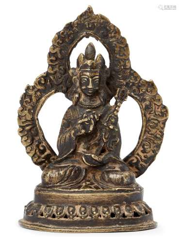 A Nepalese brass figure of Padmasambhava, 18th-19th century, holding in his right hand a vajra, in