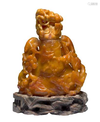 A Chinese amber vase and cover, late Qing dynasty, carved with grapes and squirrels, on hardwood