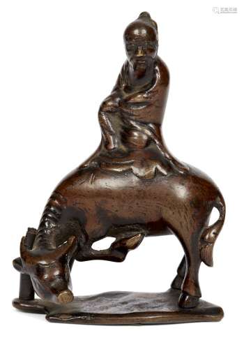 A Chinese bronze scroll weight, late Ming dynasty, modelled as Shoulao atop a buffalo, 8cm high