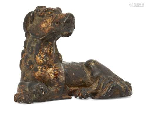 A Chinese bronze scroll weight, late Ming dynasty, modelled as a recumbent mythical beast, with