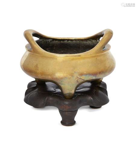 A large Chinese polished bronze tripod censer, Xuande mark, 19th century, of bombe form, with two
