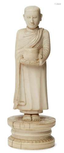 A Burmese ivory figure of a Buddhist monk, late 19th century, standing, holding a begging bowl, on