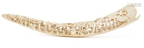 A Chinese ivory tusk carving, 19th century, the full tip tusk profusely carved with a multitude of