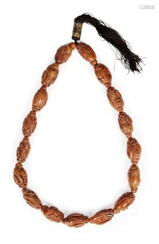 A Chinese hediau fruit nut bead necklace, early 20th century, each bead carved as a monk holding