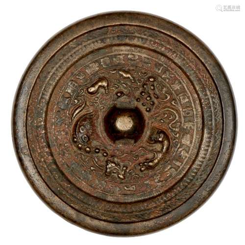 A Chinese bronze 'lion and grapes' circular mirror, Tang dynasty, the central knob encircled by