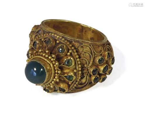 A Thai gold and filigree decorated floral ring, 19th century, set with green coloured paste