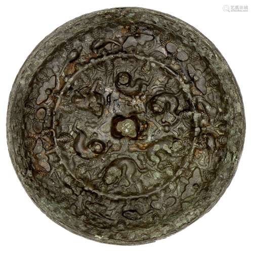 A large Chinese bronze 'lion and grapes' circular mirror, Tang dynasty, the central knob