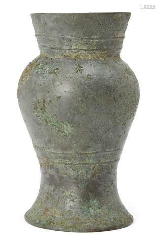 A Chinese bronze vessel, hu, Shang dynasty, with flared rim and bulbous body to spreading foot, with