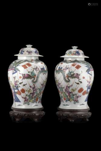 A pair of baluster jars and covers each decorated in Famille Rose with boys in a processionChina,