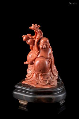 A coral carving of a seated Budai, wood baseChina, early 20th century(h. 10.5 cm.)This lot may be