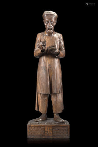 A 'nanmu' wood sculpture of a scholar, reading a book with focused expression, wearing a blouse