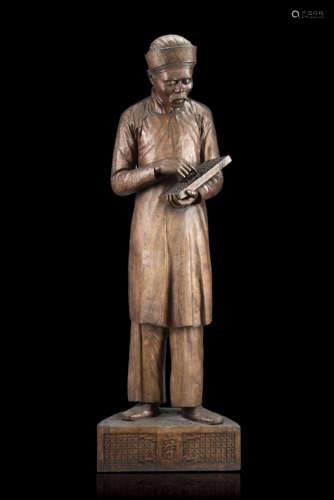 A 'nanmu' wood sculpture of a merchant, wearing a long blouse and trousers, the head covered, an