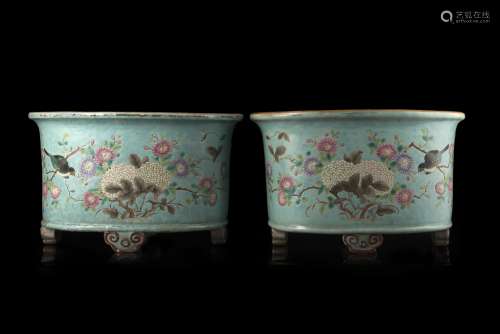 A pair of turquoise-ground Famille Rose jardinieres, decorated with floral motifs, supported by four