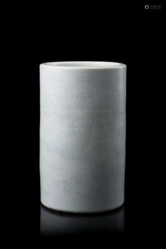 A white monochrome cylindrical brushpot, with incised decoration of dragons, with apocryphal