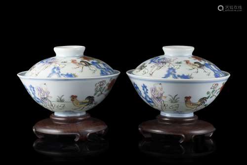 A pair of doucai cups and covers decorated with a boy tending to cockerels and calligraphy, with