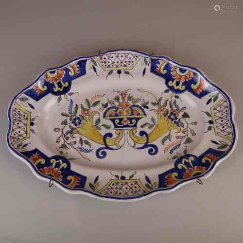 Fayence-Platte - 18./19.Jh., oval gemuldete Platte mit passig geschweiftem Rand, hellgrau<br />glasiert, polychromer floraler und ornamentaler Dekor, Wandaufhängung, rückseitig stellenweise leicht bestoßen, Alters- bzw. Gebrauchsspuren, LxB:ca.39x27,5cm