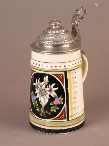 Bierkrug - Schauseite polychrom bemalt mit Blumenmotiv auf schwarzem Hintergrund, Boden<br />mit Lithophanie, Zinnmontur mit Reliefdekor, 0,5 Liter, Alters- bzw. Gebrauchsspuren, H.ca.19,2cm