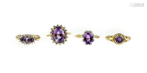 A collection of four amethyst rings