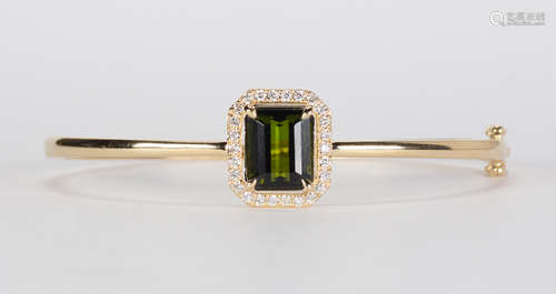 Tourmaline, diamond and 14k yellow gold bangle Centering (1) rectangle-cut green tourmaline,