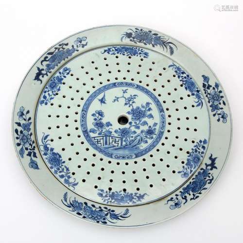 A large floral blue & white strainer with underplate