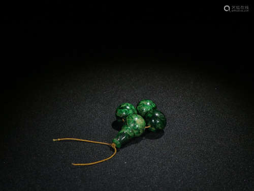 A JADEITE ORNAMENT WITH FOUR BEADS