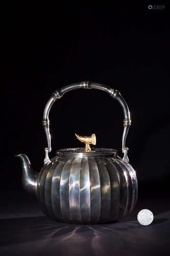 A SILVER TEAPOT WITH VERTICAL PATTERNS