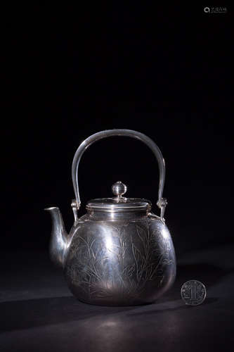 A SILVER TEAPOT WITH FLOWER PATTERNS