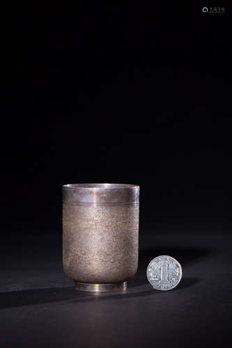 A SILVER CUP WITH SANDY SURFACE