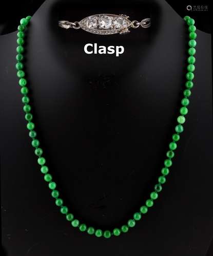 A Chinese apple green jadeite bead necklace, the seventy-five individually strung uniform beads each