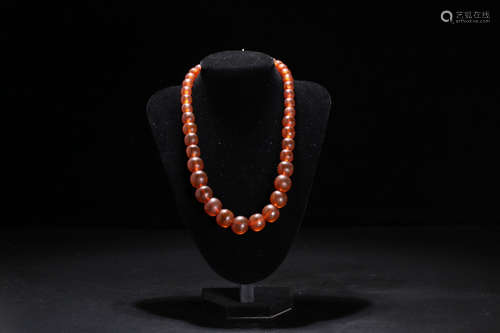 AN AMBER CARVED BEADS STRING NECKLACE